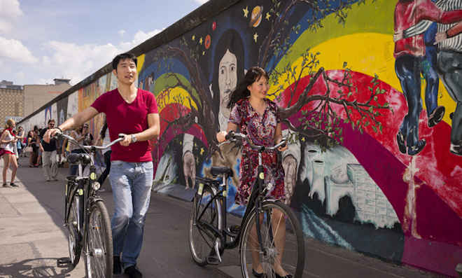 Ciclisti davanti alla East Side Gallery